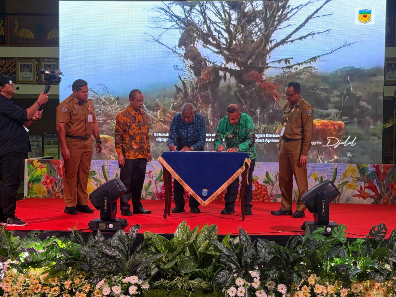 The Governor of West Papua signing the ceremonial plaque during the official launch of the Palms of New Guinea book in Manokwari, surrounded by international botanists and delegates.